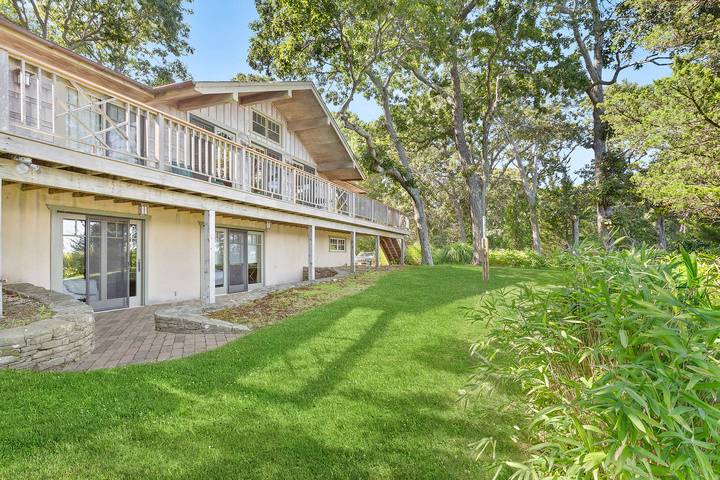 26 Duke Drive East Hampton, NY 11937 - Photo 19 of 20 a front view of a house with a garden