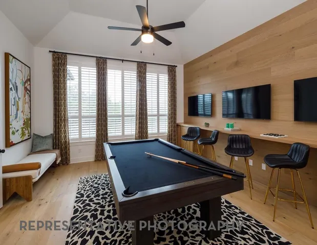 a living room with furniture a flat screen tv and a chandelier