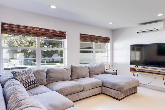 a living room with furniture a window and a ceiling fan