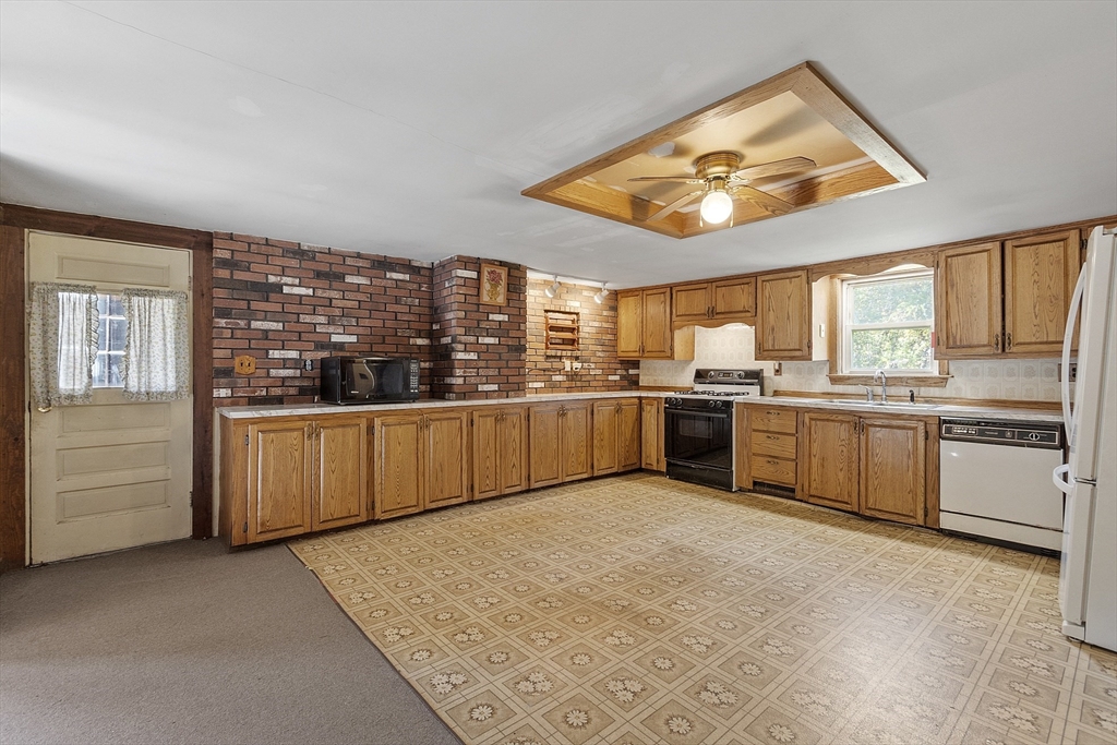 705 Richardson Road Ashby, MA 01431 - Photo 5 of 42 a kitchen with stainless steel appliances a stove a sink and white cabinets