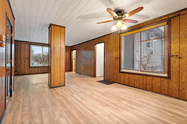 a view of an empty room with window and a kitchen