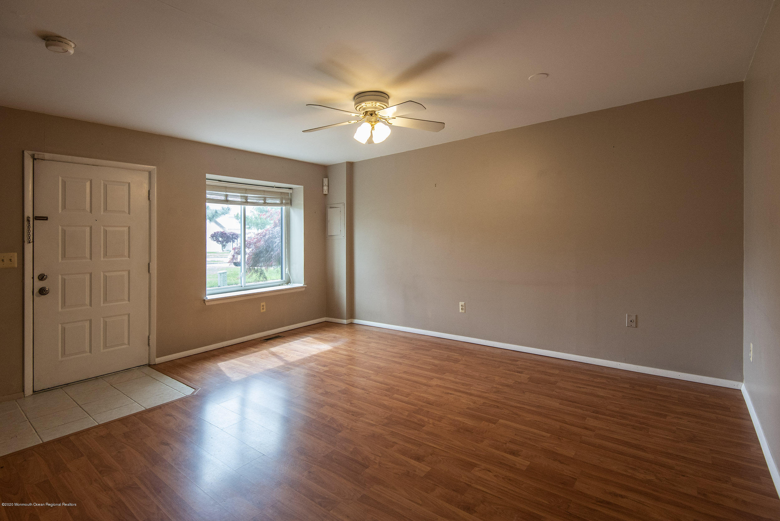 902 Sandra Place Brick, NJ 08724 - Photo 10 of 28 an empty room with wooden floor chandelier fan and windows