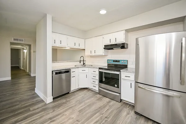a kitchen with a refrigerator stove and white cabinets