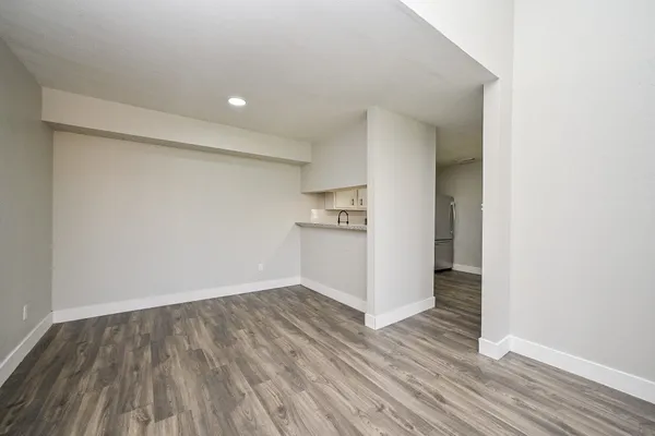 a view of an empty room with wooden floor and closet