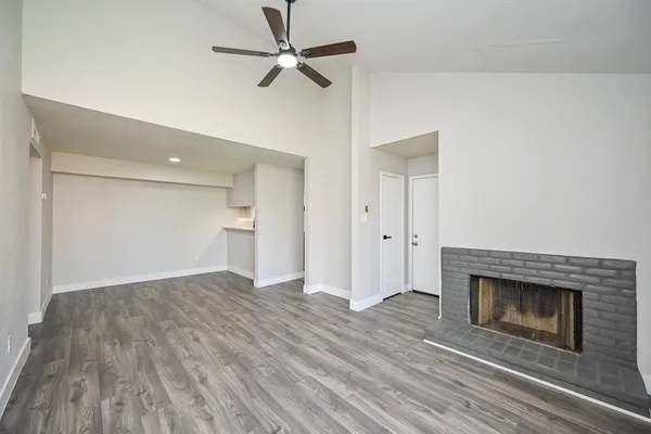 a view of empty room with wooden floor and fireplace