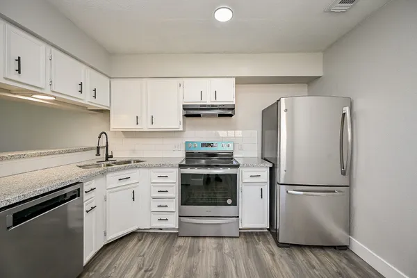 a kitchen with appliances a sink and a refrigerator