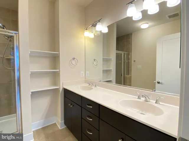 a bathroom with a double vanity sink and a mirror