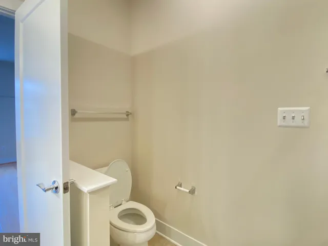 a white toilet sitting next to a white wall
