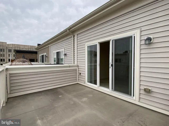 a view of a house with a barbeque and wooden fence