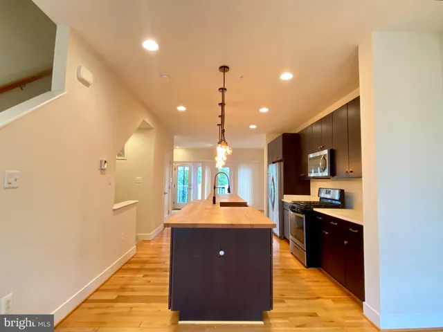 a kitchen with stainless steel appliances granite countertop a sink a stove and a refrigerator