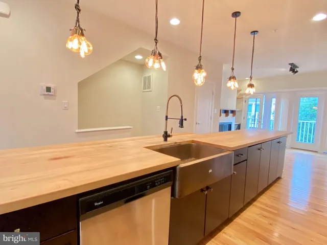 a kitchen with kitchen island a sink and a chandelier