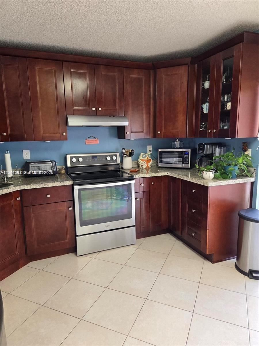 2174 West 60th Street, Unit 17205 Hialeah, FL 33016 - Photo 4 of 11 a kitchen with stainless steel appliances granite countertop a stove sink and cabinets