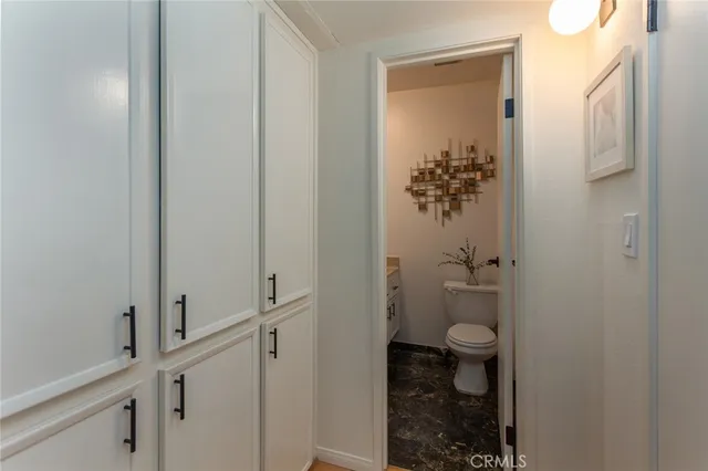 a bathroom with a granite countertop sink toilet and mirror