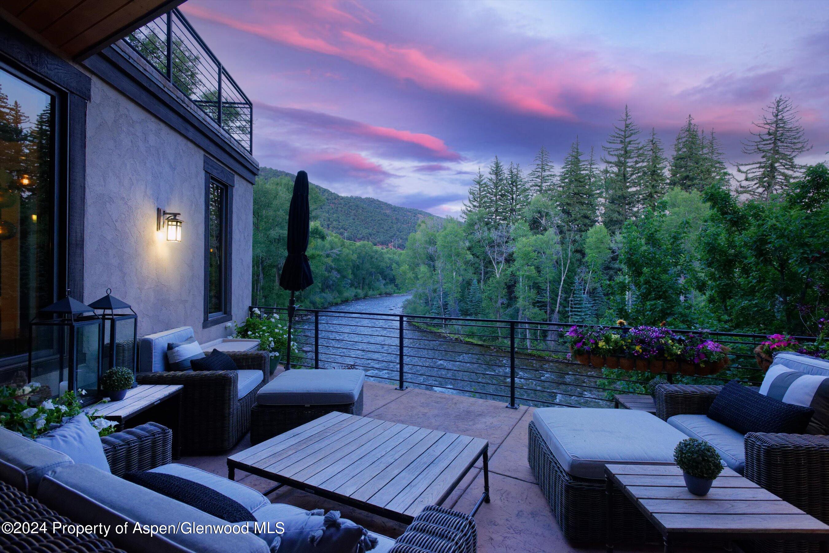 48 River Bend Road Snowmass, CO 81654 - Photo 11 of 32 a view of a patio with couches and table and chairs and potted plants