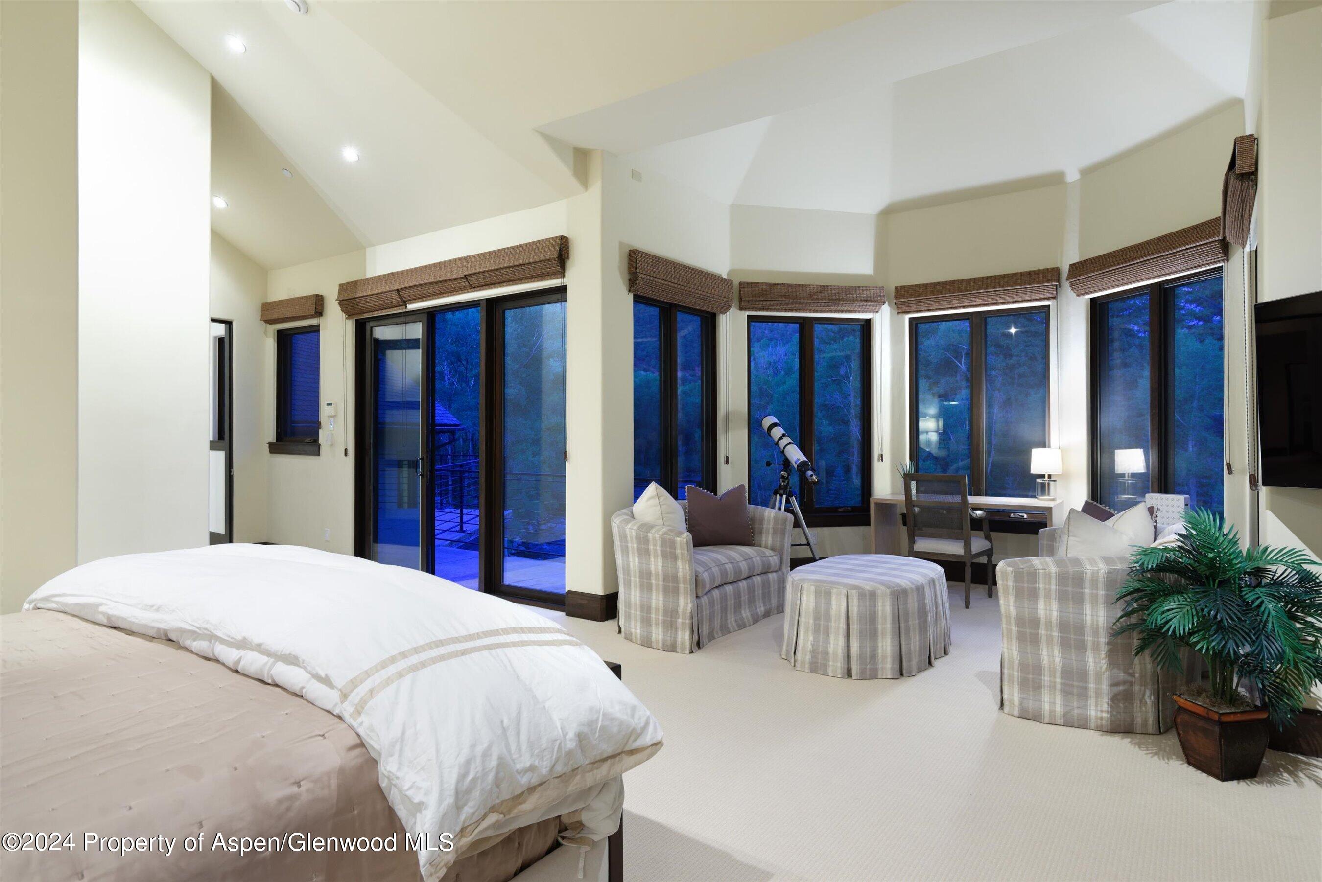 48 River Bend Road Snowmass, CO 81654 - Photo 13 of 32 a spacious bedroom with a balcony a large bed and a couch