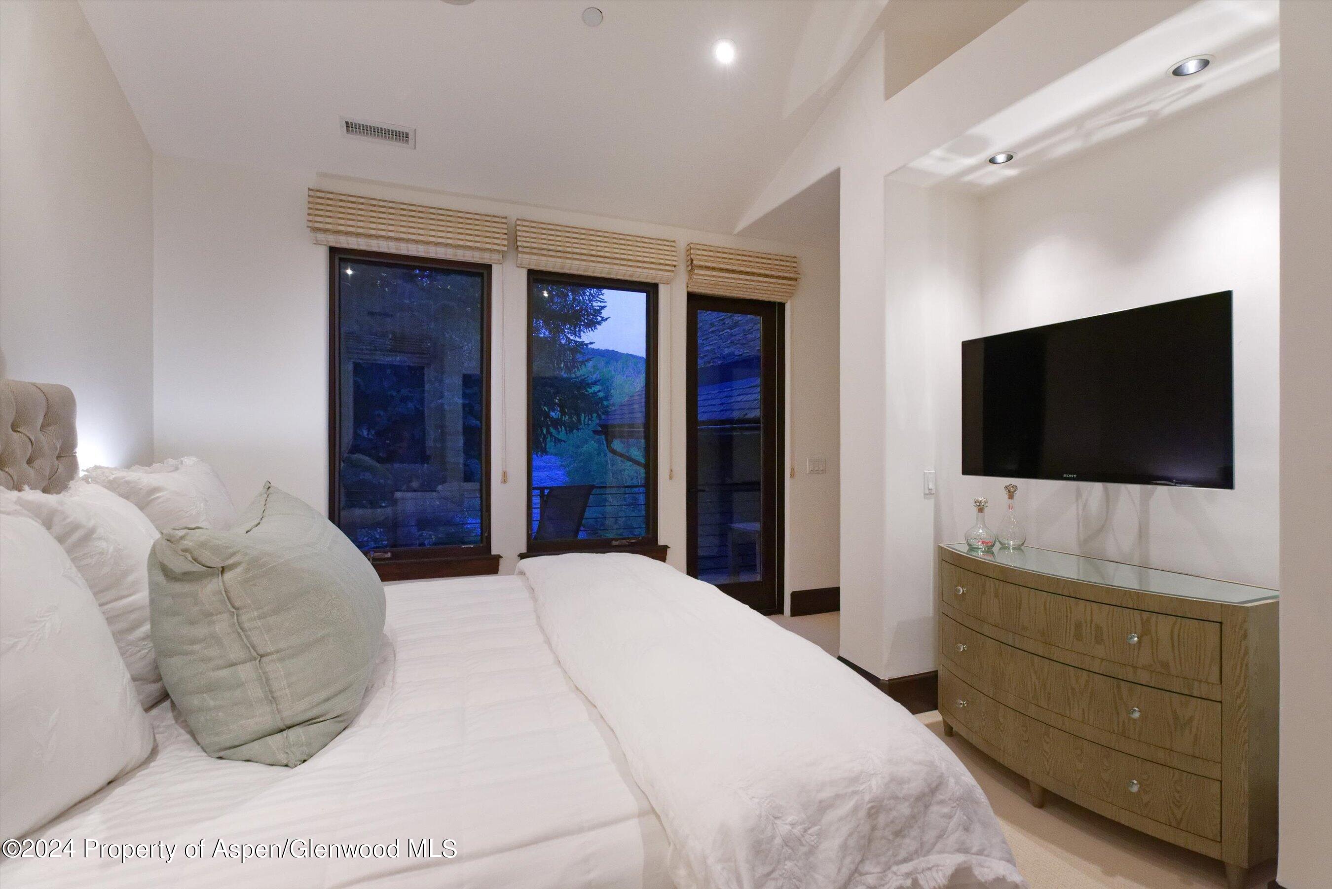 48 River Bend Road Snowmass, CO 81654 - Photo 14 of 32 a bedroom with a bed and a flat screen tv