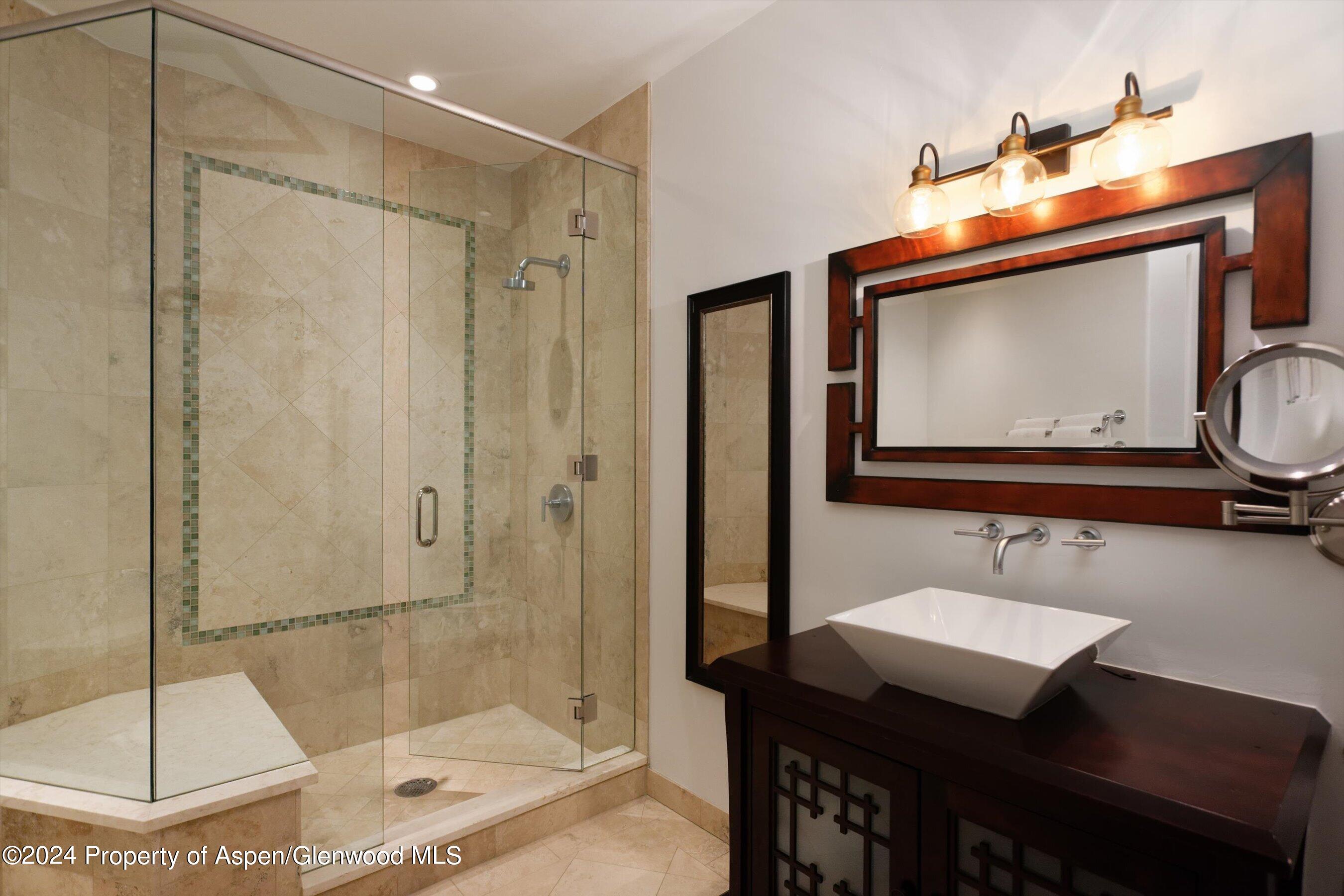 48 River Bend Road Snowmass, CO 81654 - Photo 16 of 32 a bathroom with a sink a mirror and a shower