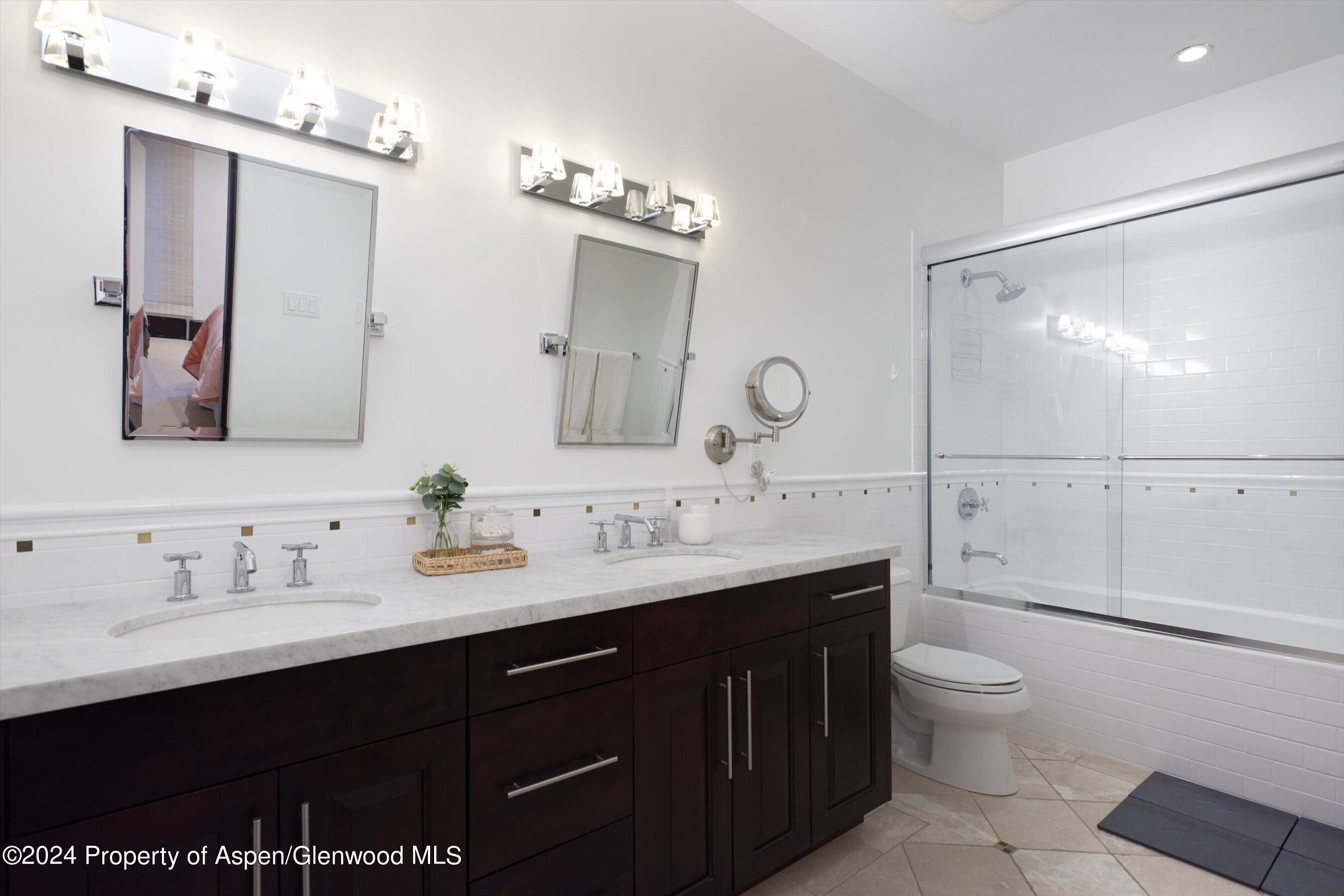 48 River Bend Road Snowmass, CO 81654 - Photo 23 of 32 a bathroom with a double vanity sink toilet mirror and shower