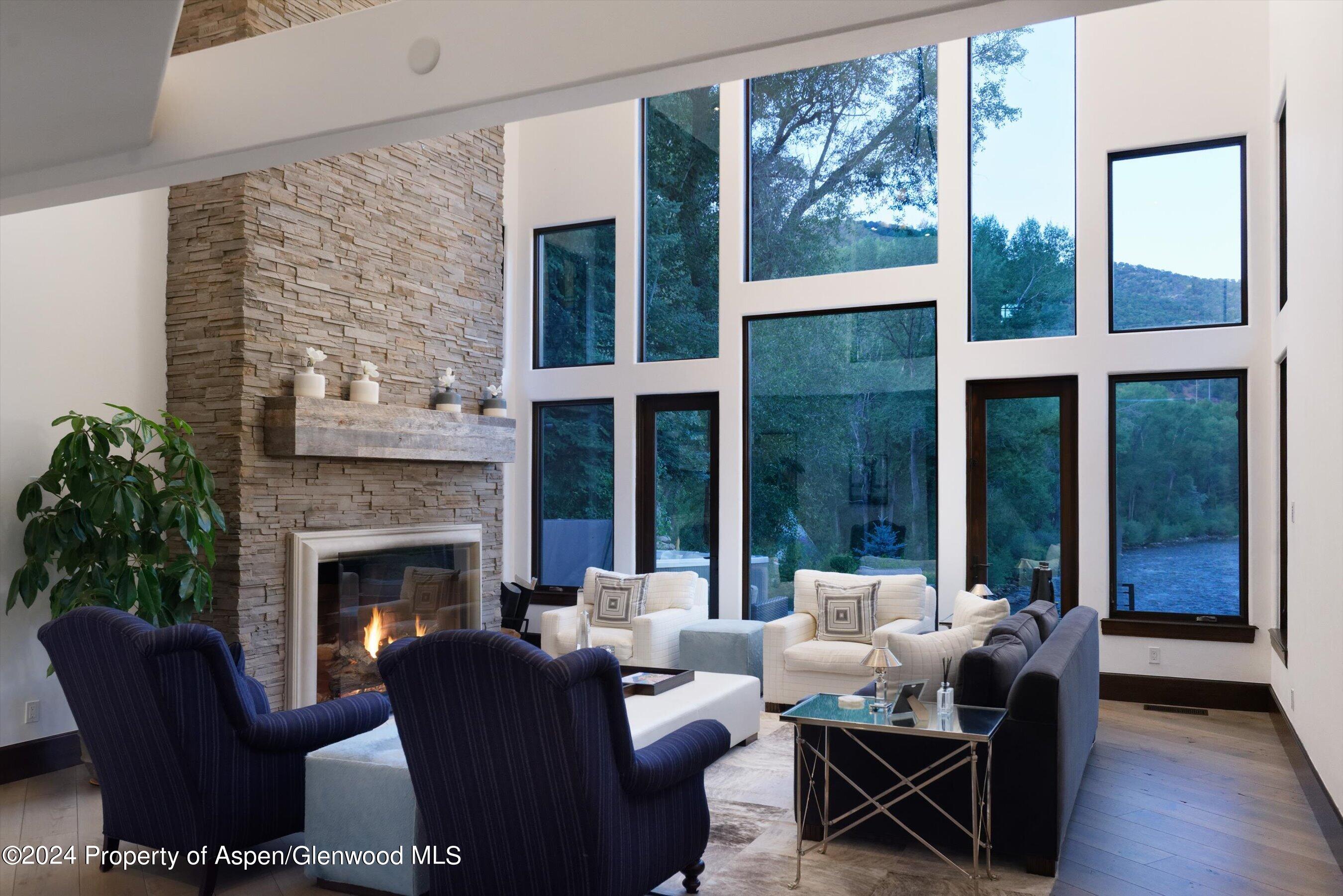 48 River Bend Road Snowmass, CO 81654 - Photo 6 of 32 a living room with furniture a large window and a fireplace