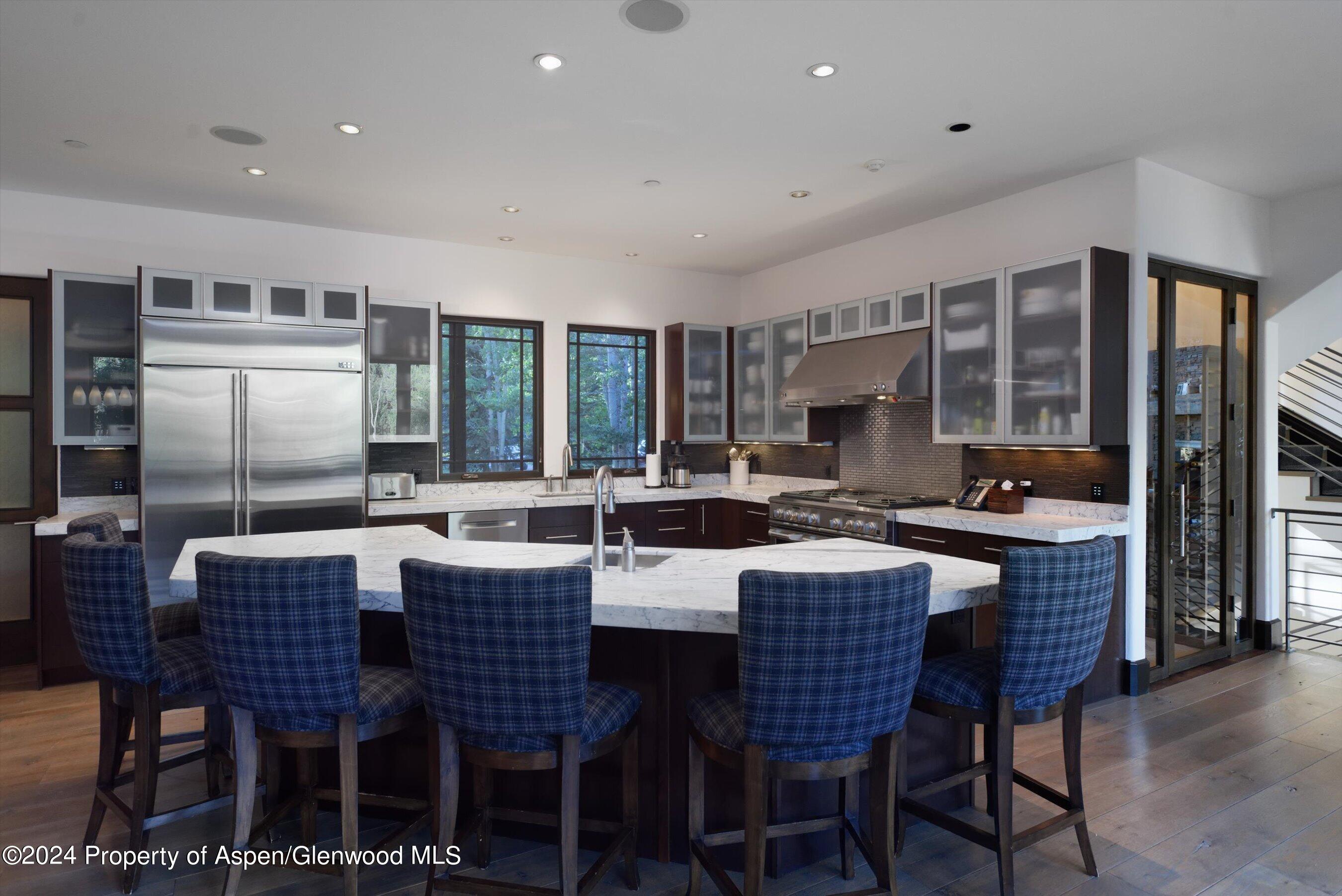 48 River Bend Road Snowmass, CO 81654 - Photo 8 of 32 a dining area with stainless steel appliances granite countertop a table chairs and a refrigerator