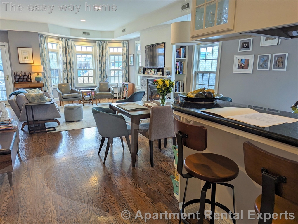 a dining hall with couches a coffee table and chairs with wooden floor