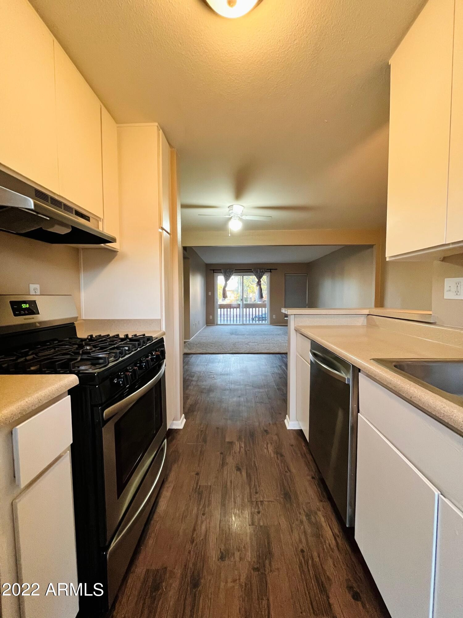 1701 West Tuckey Lane, Unit 225 Phoenix, AZ 85015 - Photo 5 of 13 a kitchen with granite countertop a stove and a wooden floors