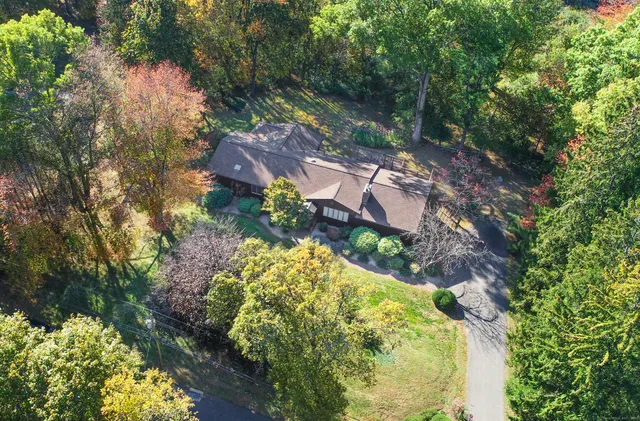 a aerial view of a house with a yard and large trees