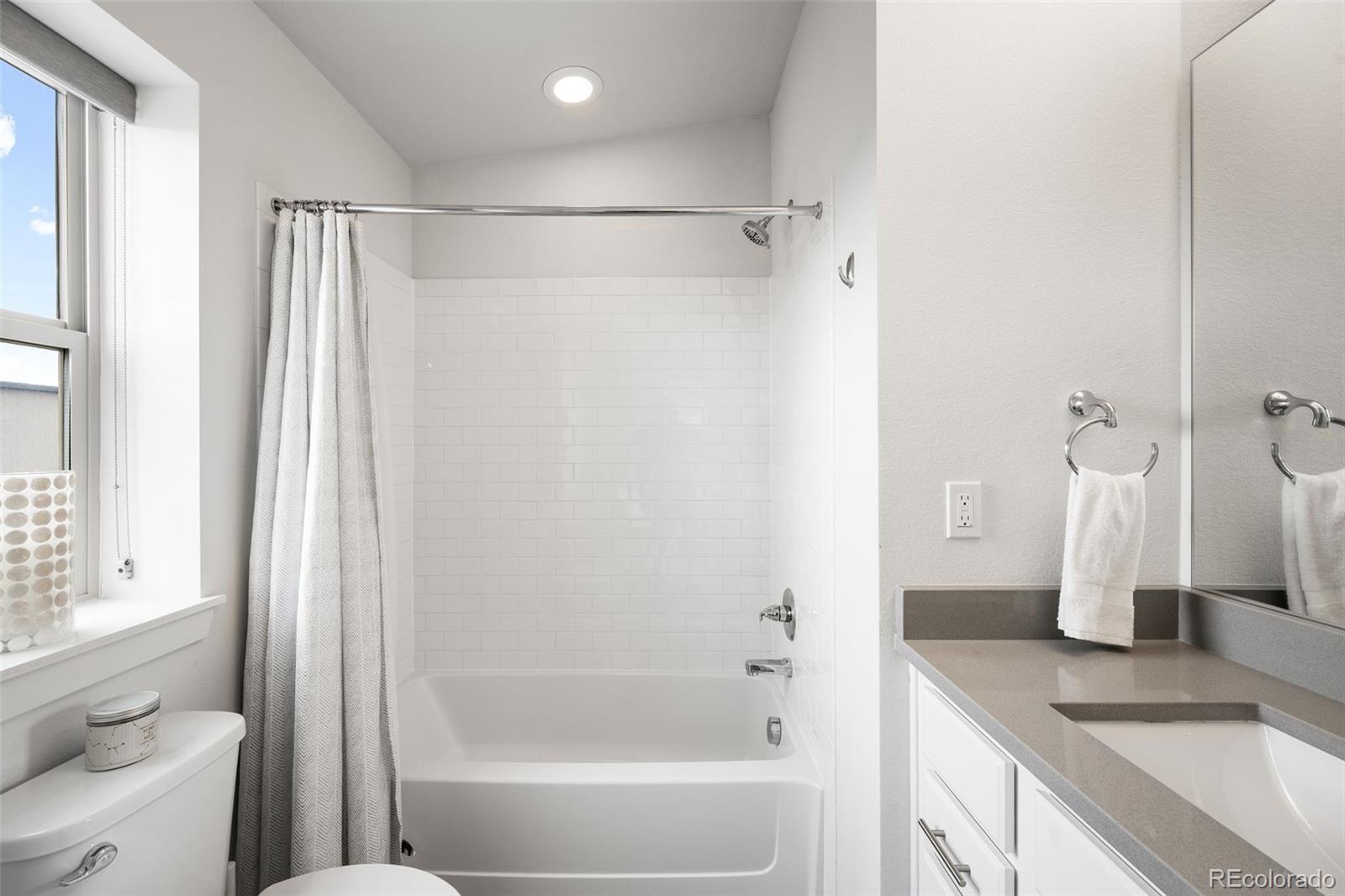10053 Town Ridge Lane Lone Tree, CO 80124 - Photo 16 of 17 a bathroom with a granite countertop sink mirror and a bathtub