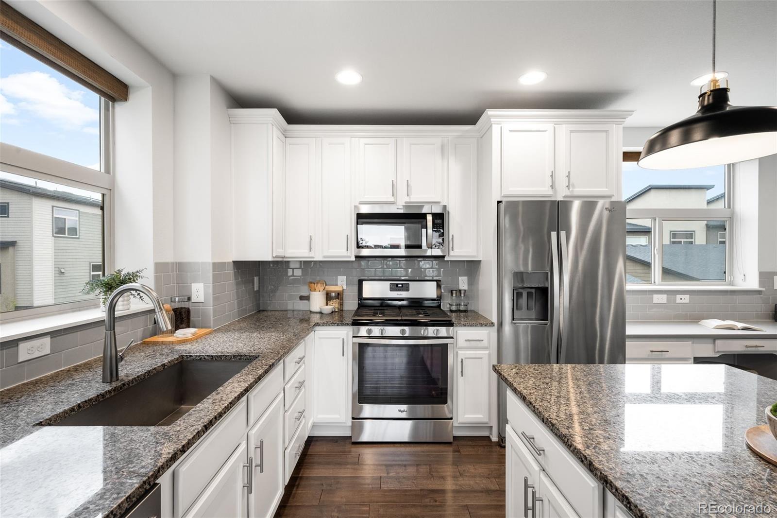 10053 Town Ridge Lane Lone Tree, CO 80124 - Photo 5 of 17 a kitchen with stainless steel appliances granite countertop a refrigerator a stove and a sink
