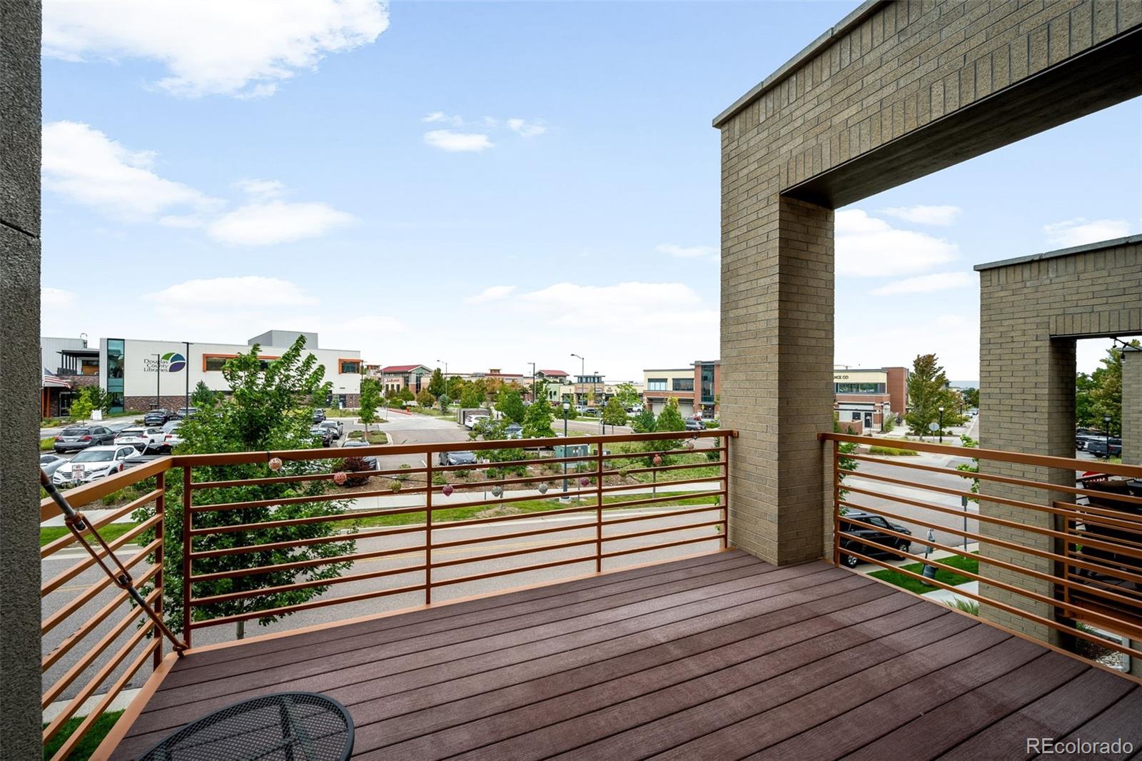 10053 Town Ridge Lane Lone Tree, CO 80124 - Photo 10 of 17 a view of a balcony with wooden floor next to a yard