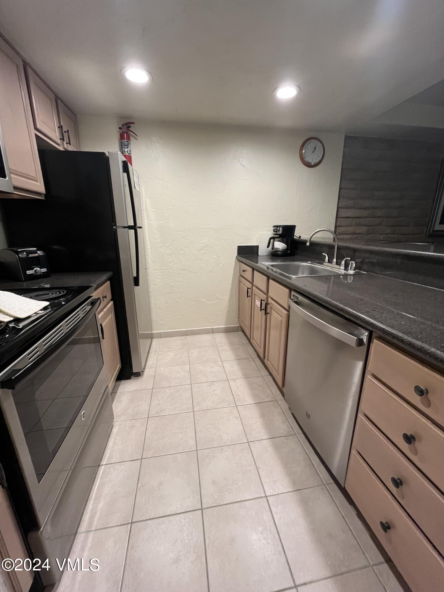 1020 Vail View Drive, Unit 230125 Vail, CO 81657 - Photo 2 of 19 a kitchen with a sink stainless steel appliances and cabinets