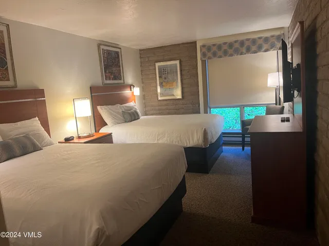 a bed room with a bed window and a flat screen tv