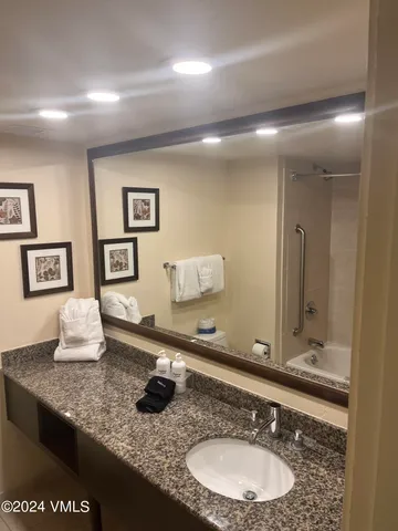 a bathroom with a granite countertop sink a mirror and vanity