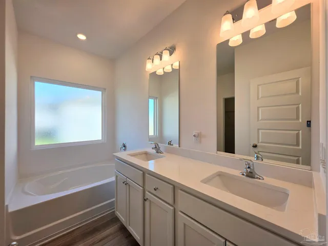 a bathroom with a sink a large mirror and a bathtub with shower