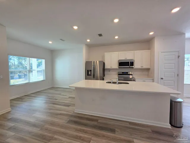 a kitchen with stainless steel appliances a refrigerator sink and microwave