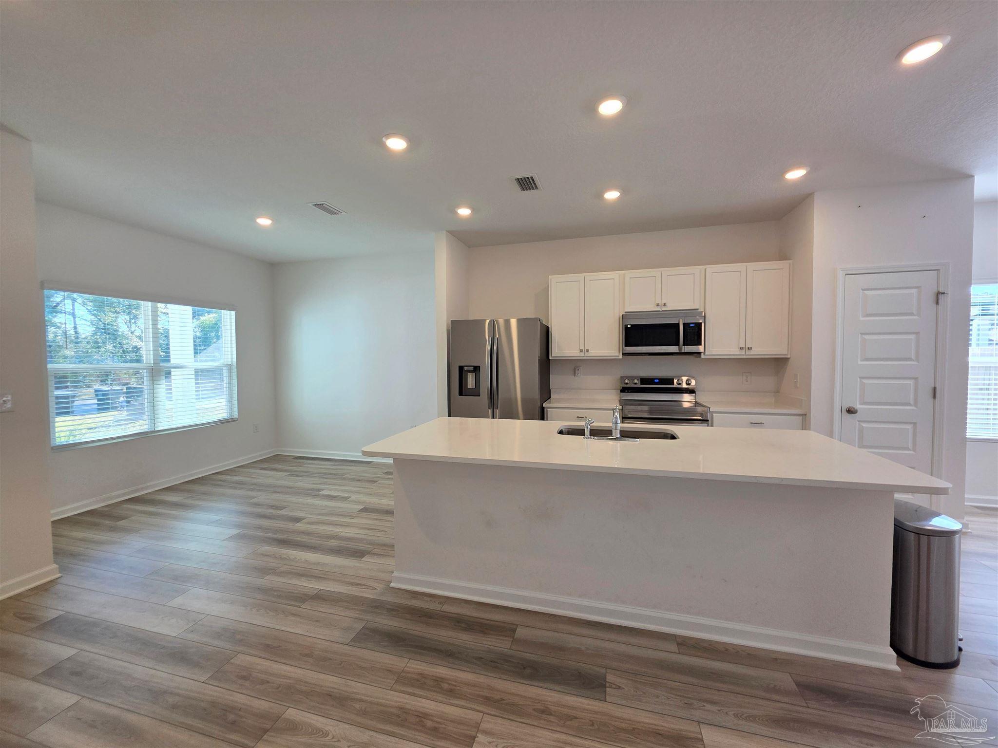 9613 Sagewood Drive Pensacola, FL 32526 - Photo 3 of 27 a kitchen with stainless steel appliances a refrigerator sink and microwave