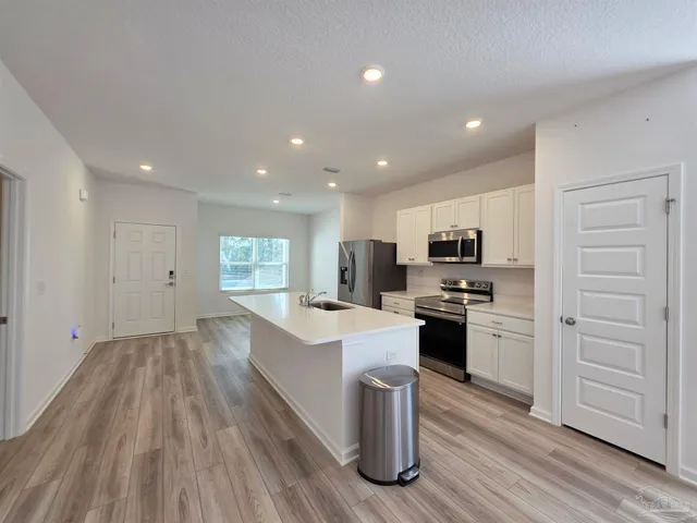 a large kitchen with a large counter top appliances and cabinets