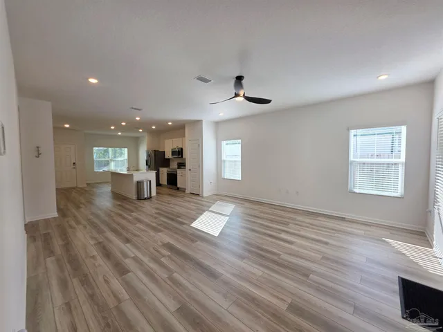 a view of a living room a kitchen and a wooden floor