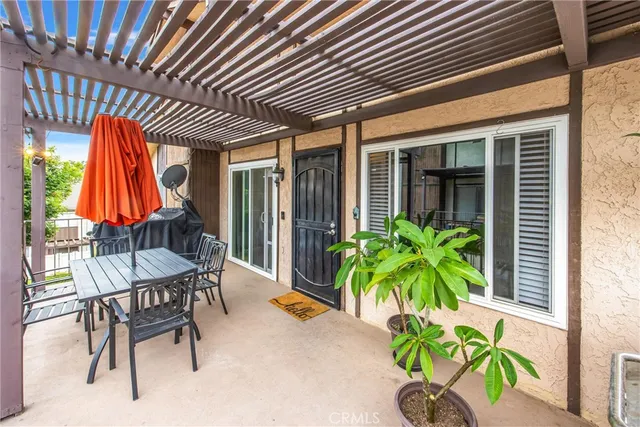 a patio with a table and chairs and potted plants
