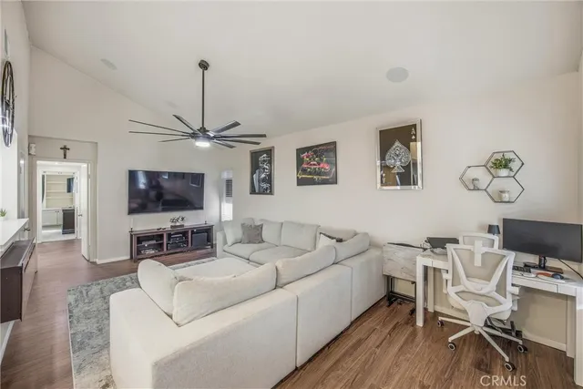 a living room with furniture a flat screen tv and kitchen view