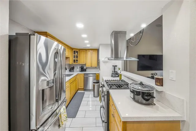 a kitchen with stainless steel appliances granite countertop a refrigerator and a stove