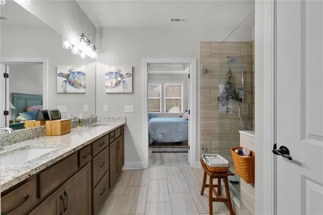 a spacious bathroom with a granite countertop sink a toilet a mirror and shower