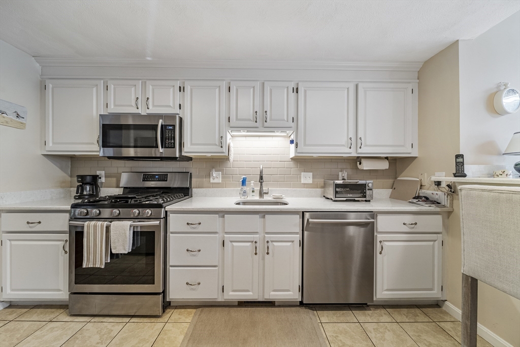 21 Tulip Circle, Unit 21 Haverhill, MA 01830 - Photo 4 of 26 a kitchen with cabinets stainless steel appliances and sink