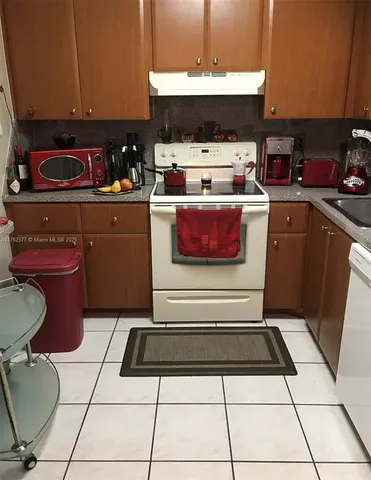 a kitchen with a stove a sink and a microwave
