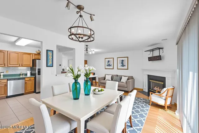 a view of a dining room with furniture a chandelier and wooden floor
