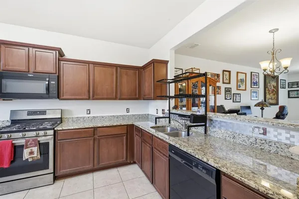 a kitchen with stainless steel appliances granite countertop a sink stove and cabinets