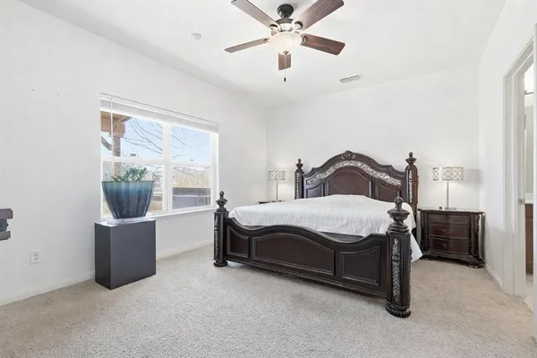 a bedroom with a bed lamp and window