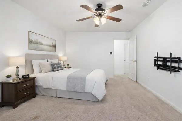 a spacious bedroom with a bed and a chandelier