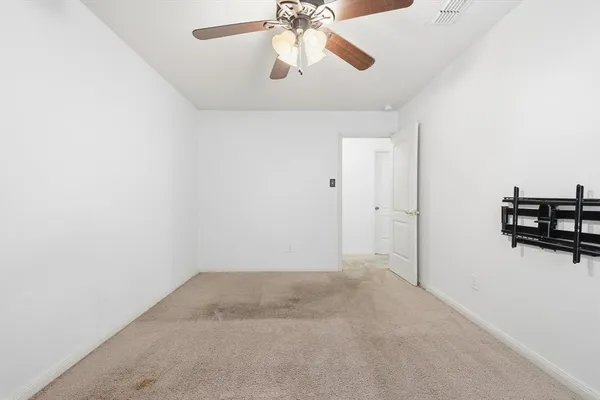 an empty room with chandelier fan