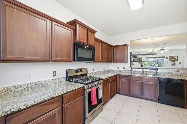 a kitchen with stainless steel appliances granite countertop a sink and stove top oven